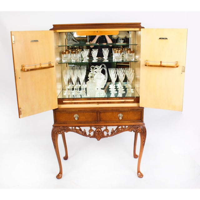 Mid-Century burr walnut cocktail drinks cabinet, two doors, glass shelves with mirrored back base and brush slide, above...