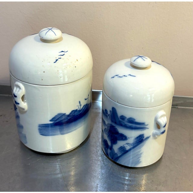 Hand-painted blue/white ceramic lidded asian canisters/jars; set of two. Some mild discoloration spots on one side of one...