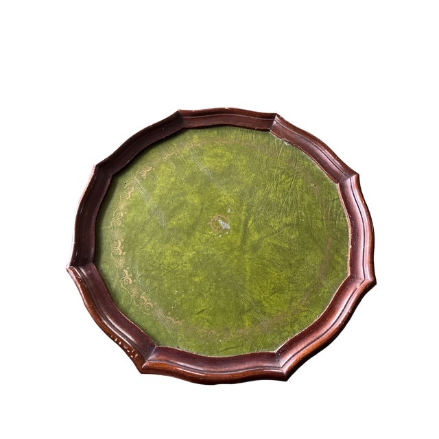 A charming and highly versatile small-scale drinks table featuring a rich green leather inset top framed by a scalloped...