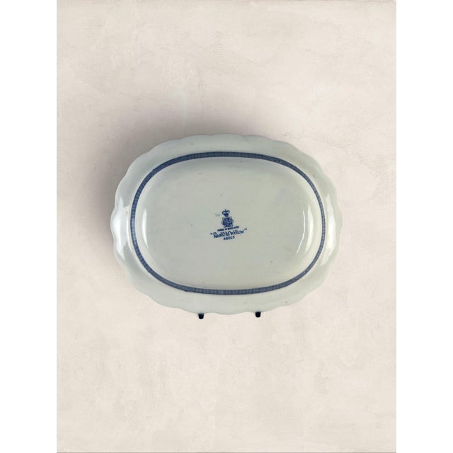 An antique English ironstone serving platter by Booths in the iconic “Real Old Willow” pattern, dating to circa 1920....