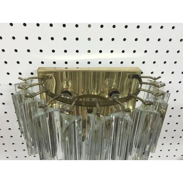 Stunning pair of Italian Mid-Century Modern sconces by Venini. Having a brass frame and two-tier of beautiful glass prisms.
