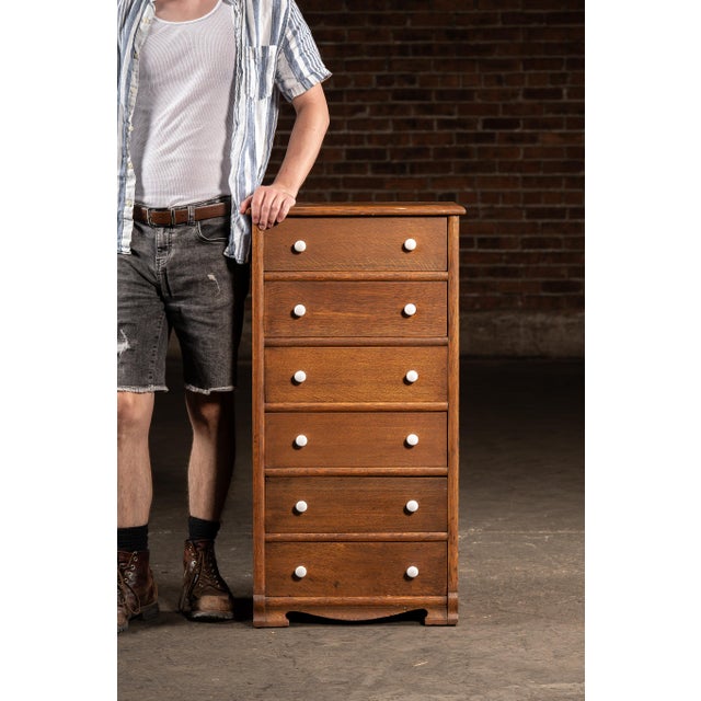 Solid oak swing-out drawer cabinet featuring seven pivoting compartments, each hinged to open laterally from the left...