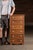 Solid oak swing-out drawer cabinet featuring seven pivoting compartments, each hinged to open laterally from the left...