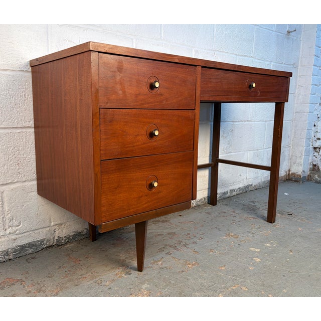 Elegant mid-century modern writing desk featuring a warm walnut wood frame and a durable Formica top. The clean lines and...