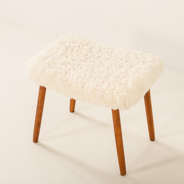 A danish mid-century footstool produced in the 1960s, featuring solid wood legs and newly upholstered in natural...
