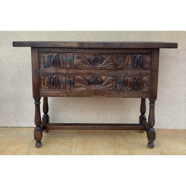 Walnut console from the early 20th century with tablet top on a frieze with two drawer fronts decorated with carved with...