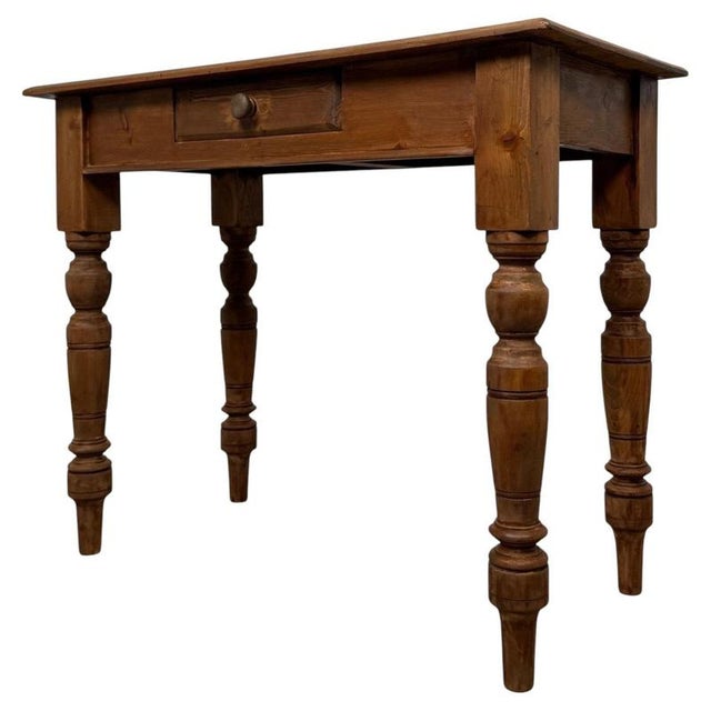 A charming vintage 20th-century English side table, well crafted from pine and distinguished by its practical single-...