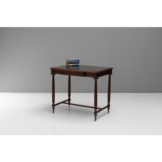 French mahogany side table with inset leather top and applied decorative brass mounts. Circa 1900.
