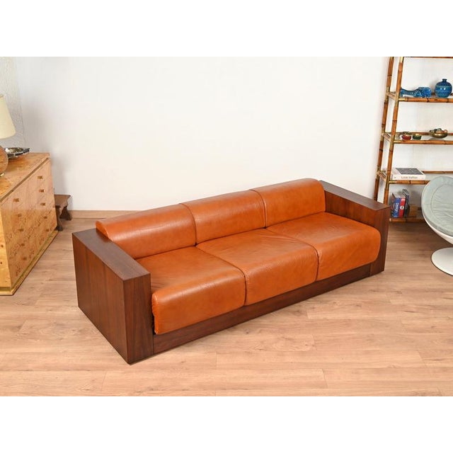 Stunning and truly one-of-a-kind custom-made three-seat Italian sofa in precious wood and beautiful cognac leather. This...