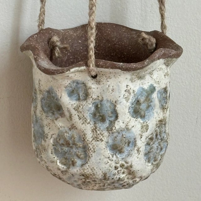 Looking to add a little flower power to your room design? Well, this adorable artisan-crafted stoneware hanging planter...