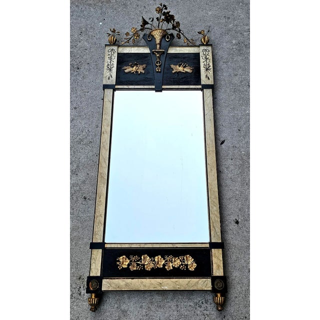 Featured is a fine gilt pier mirror with wooden and metal flower basket crest, flanked by two corner foliate finials over...