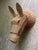 A large woven wicker horse head with a brown vinyl harness with perky ears and raised eyebrows and a little woven bow...