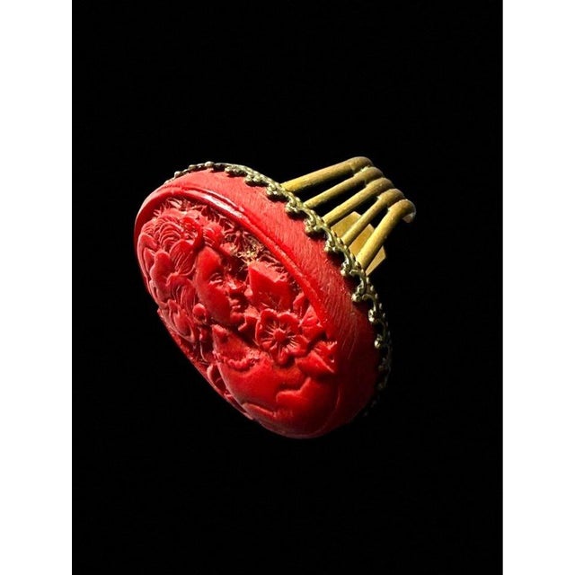 Jan Michaels adjustable ring featuring a carved red coral stone set in a gold-toned metal band, made in San Francisco. -...