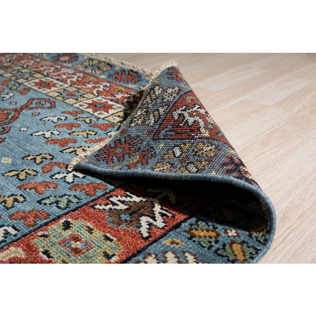 A hand-knotted wool rug, made in India and measuring 8' x 10'. A centre medallion anchoring the field, framed by a...