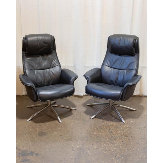 A matched pair of reclining leather lounge chairs by IMG Comfort of Norway, offered here with both original ottomans — a...