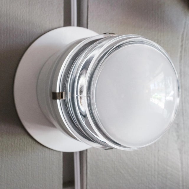 Pair of Joe Colombo 'Fresnel' Outdoor Wall Lamps for Oluce in white. Executed in lacquered aluminum and glass, this is one...