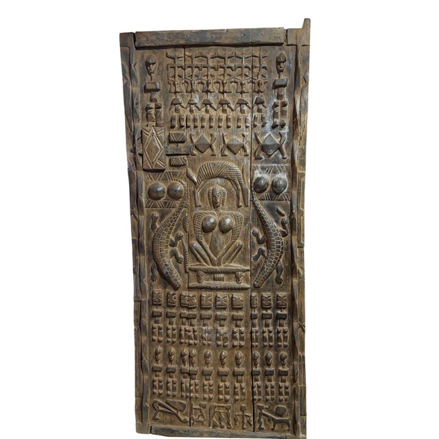 This vintage Dogon granary door from Mali features intricate carved relief figures— standing Nommo ancestors the bottom...