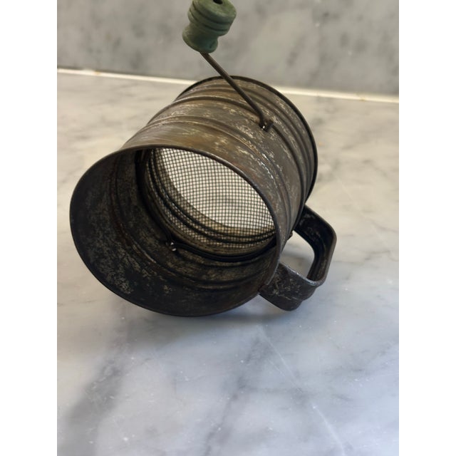 Authentic early 20 th century kitchen ware. 1 cup midget flour sifter. classic single wire rotary crank . Tin plate...