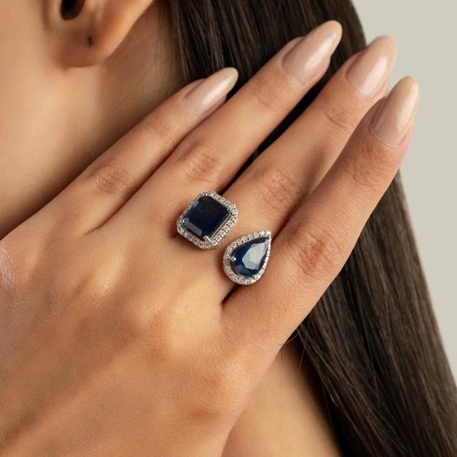 This elegant Toi et Moi engagement ring features 2 pear and emerald cut blue sapphires totaling 5.32 carats, set in rich...