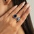 This elegant Toi et Moi engagement ring features 2 pear and emerald cut blue sapphires totaling 5.32 carats, set in rich...