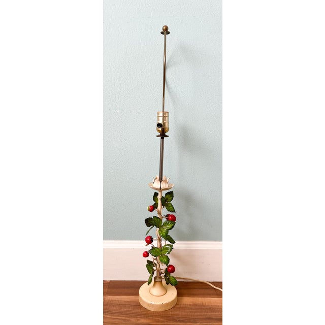 Delightful vintage tole table lamp featuring hand-painted metal strawberries, leaves, and flowers winding up a slender...