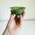 An intriguing Chinese spinach jade bowl, a classic piece of carved lapidary art crafted from translucent green nephrite...