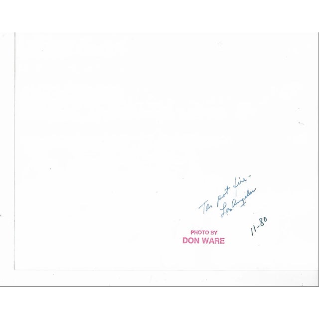 1980 black and white photo by Los Angeles photographer Don Ware of a fireman extinguishing a tar pot fire from a...