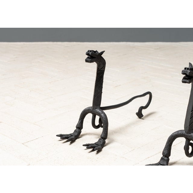 USA, ca. 1920s. A fantastic pair of andirons attributed to the workshop of Samuel Yellin. Each features wrought iron...