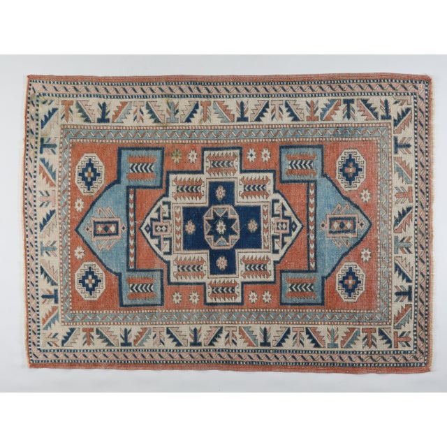 A striking vintage tribal rug handwoven from pure wool, featuring a bold geometric medallion design rendered in rich rust,...