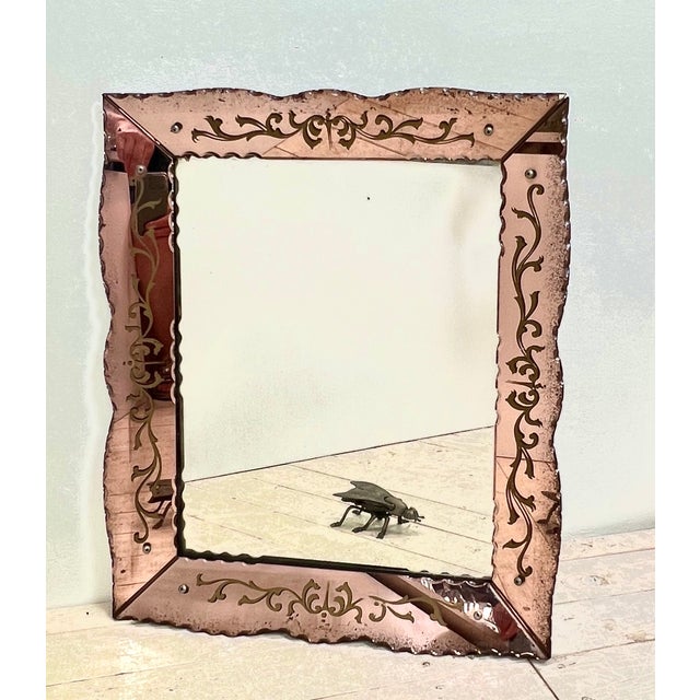 1960s Venetian mirror in pink tinted glass. The glass is scalloped, engraved, bevelled and with beautiful details. It is...
