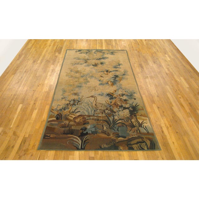 A French Aubusson verdure tapestry panel from the late 19th century, depicting a heron in front of a lake, surrounded by...