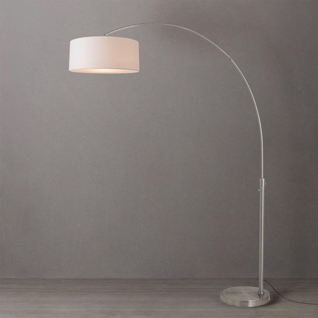 Satin nickel steel paired with a satin nickel base defines the Float Arc Lamp, a modern arc lamp designed by Peter Morelli...