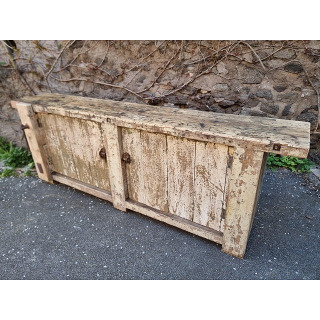 A substantial antique French workbench in solid pine, dating from the early 20th century. This piece is defined by its...