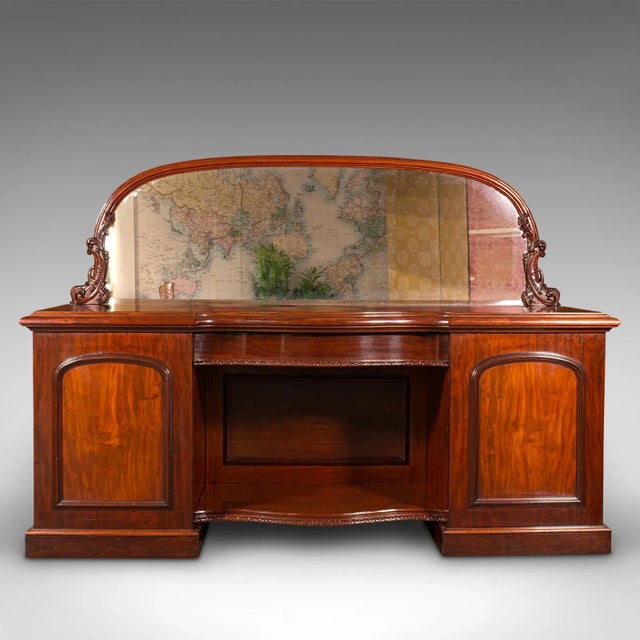 This is a very large 7' 6" antique pedestal sideboard. An English, mahogany dresser cabinet with mirror, dating to the mid...