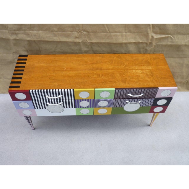 Small, low, vintage-style sideboard with two drawers and two drop-down doors. Lacquered wood frame with inlaid round...