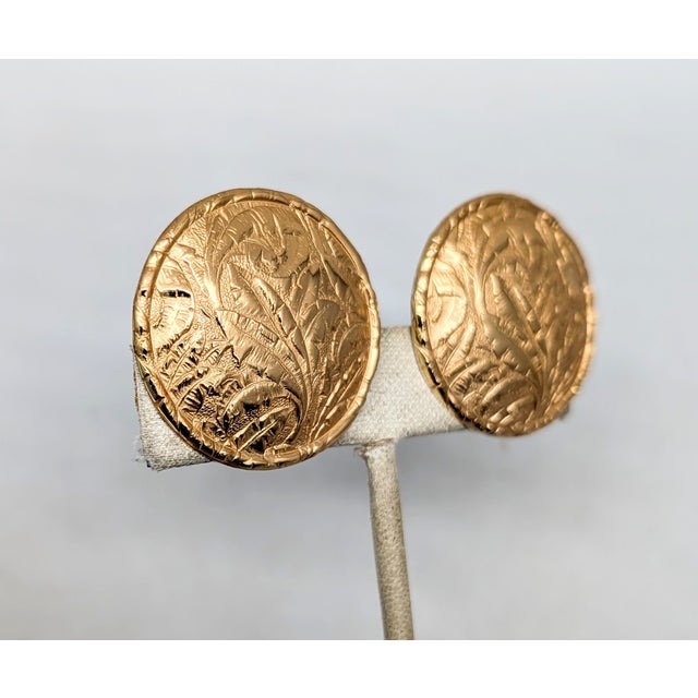1960s goldtone round domed with raised leaf pattern clip earrings. Marked "NAPIER PAT. PEND." Measure: 1 1/4 inches...