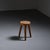 A tripod stool crafted from solid wood in the French Alps around the 1950s. Its thick, circular seat rests on three...
