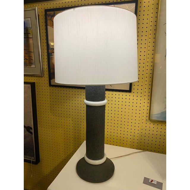 This sculptural table lamp features a minimalist design characteristic of the Memphis style. Crafted from grey and white...