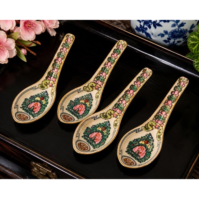 A charming set of four vintage porcelain Chinese soup spoons featuring hand-decorated floral motifs, traditional longevity...