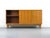 Stunning walnut sideboard with two sliding doors featuring oval recessed handles and six drawers with delicate, teardrop-...