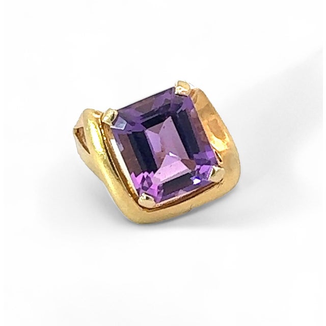 A gorgeous and boldly proportioned Retro cocktail ring featuring a richly colored faceted amethyst set in substantial 14K...