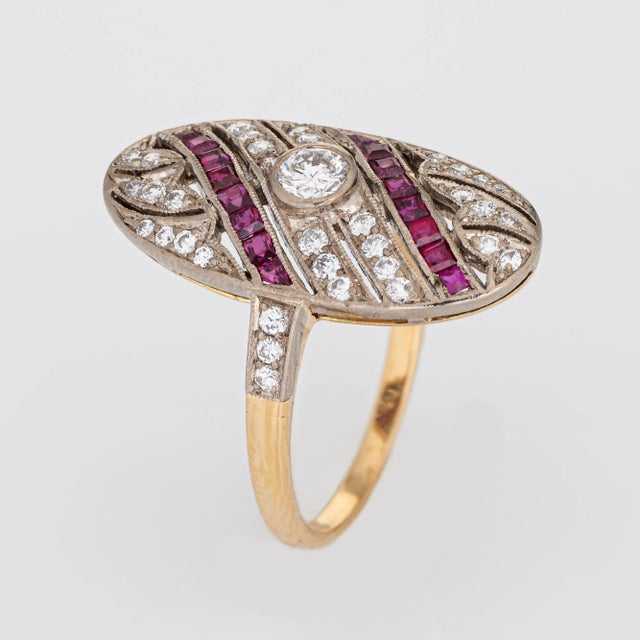 Stylish estate ruby & diamond ring crafted in 18 karat white & yellow gold. Round brilliant cut diamonds total an...