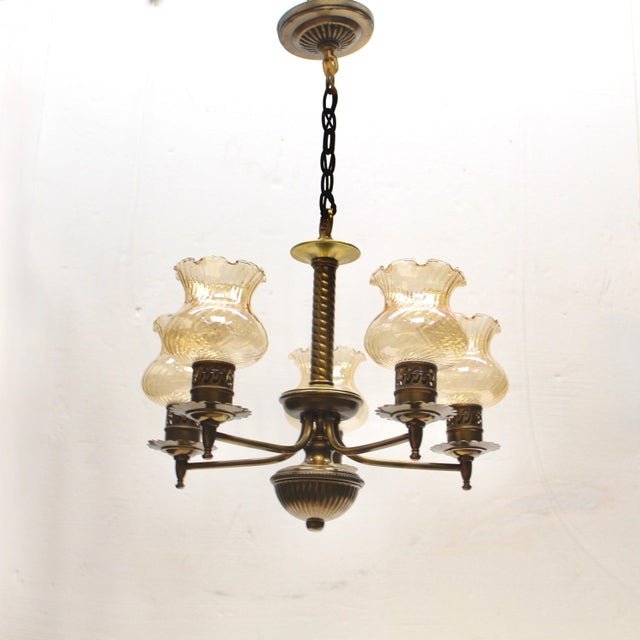 Distinctive twisted central column with 5 curved brass arms each supporting a delicate swirled glass shade. Brass...