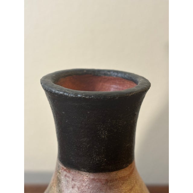 A hand-thrown American studio ceramic vase from the mid-century period. The body features a marbled clay composition in...