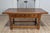 An Italian Tuscan walnut refectory table from circa 1790 with carved scoop motifs, three drawers, turned legs and plain...