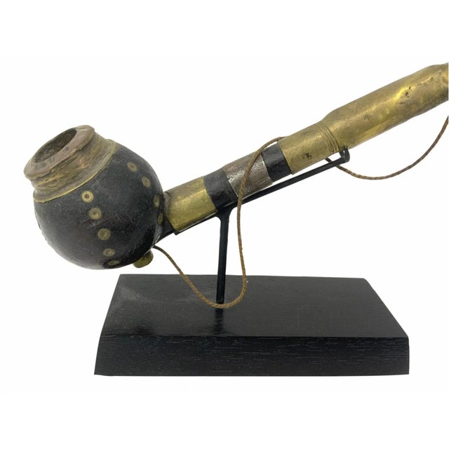 An early 20th century finely carved African ceremonial pipe of the Dinka tribe professionally mounted on an iron and wood...