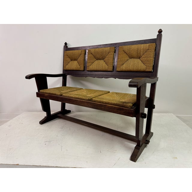 Bench with rush seats and backs A striking 1960s oak and rush bench, crafted in the style of Charles Dudouyt. This...