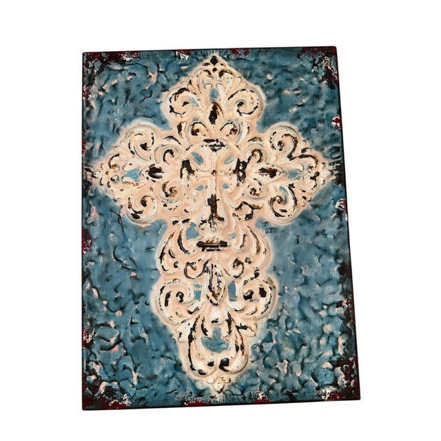 A striking piece of dimensional metal wall art featuring an ornate fleur-de-lis-inspired scrollwork motif in distressed...