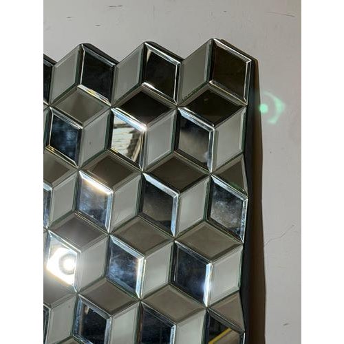 Striking sculptural wall mirror composed of a grid of three-dimensional mirrored cube facets. Each mirrored element is...