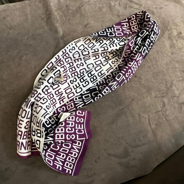 This striking 21st Century Dolce & Gabbana scarf is a fashionable accessory featuring a bold, continuous logo pattern in...